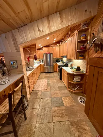 a room with stainless steel appliances lots of counter space and a table