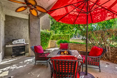 a patio with tables and chairs and a umbrella
