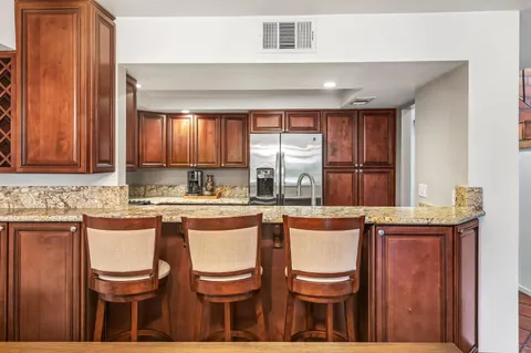a kitchen with a sink and chairs