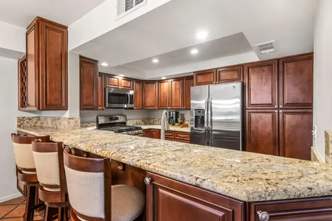 a kitchen with stainless steel appliances granite countertop a sink refrigerator and microwave