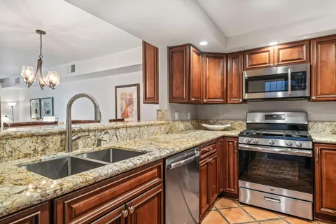 a kitchen with granite countertop a stove sink and microwave