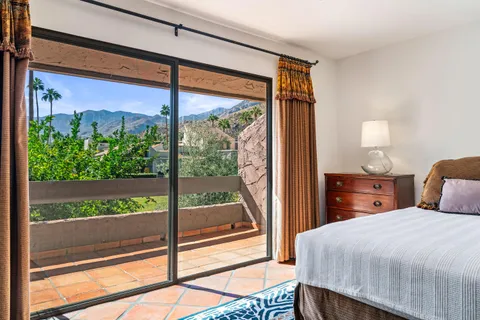 a bedroom with a bed and a balcony view