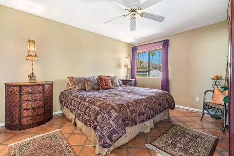 a bedroom with a bed a dresser and chair