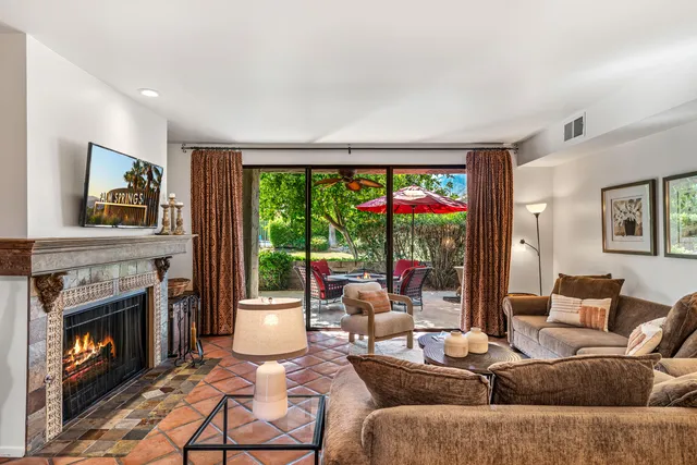 a living room with furniture a fireplace and a flat screen tv