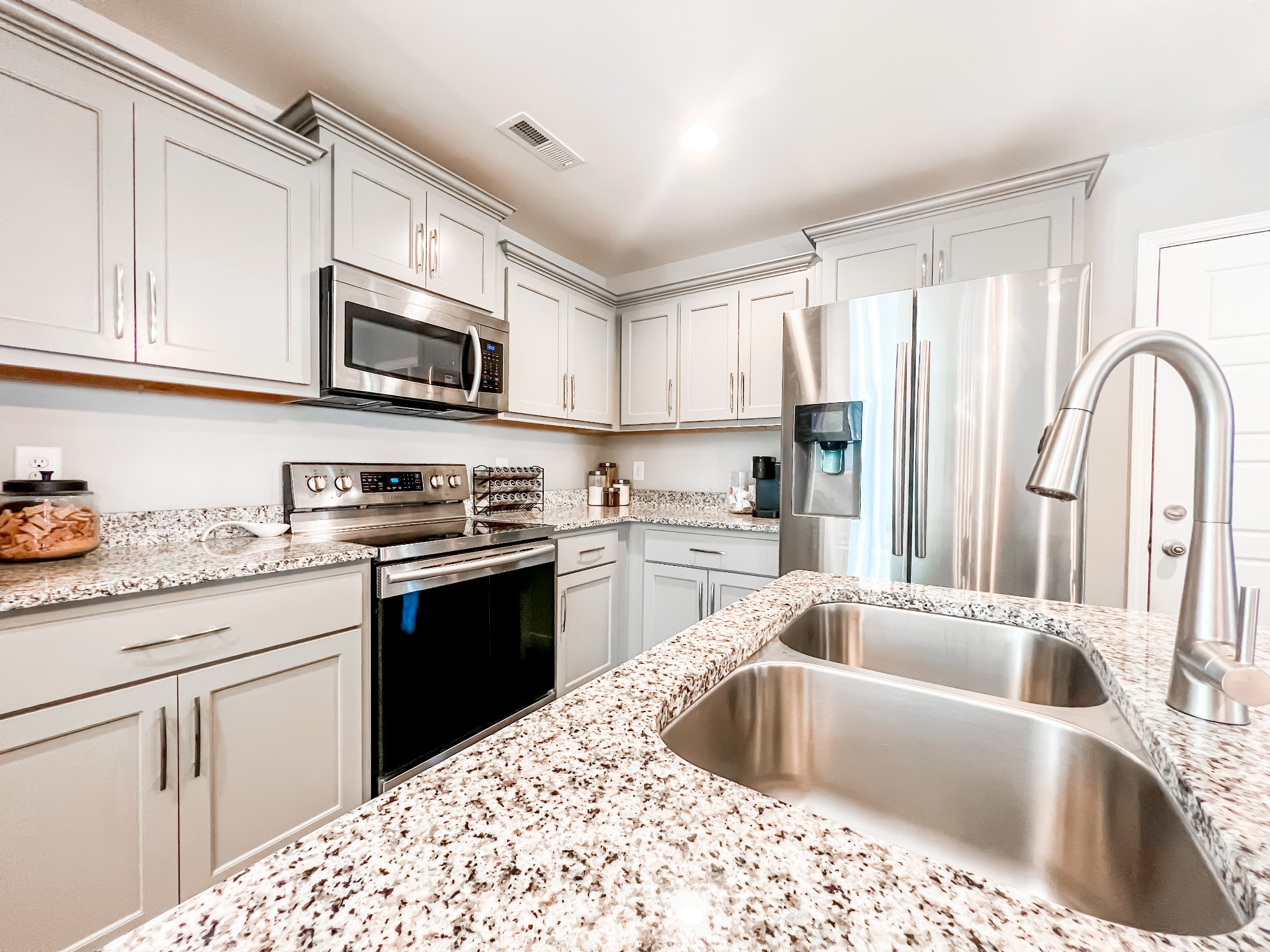509 Skipping Stone Road Christiana, TN 37037 - Photo 9 of 33 a kitchen with stainless steel appliances kitchen island granite countertop a sink dishwasher stove and white cabinets with wooden floor