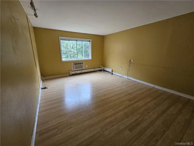 a view of a room with wooden floor and window
