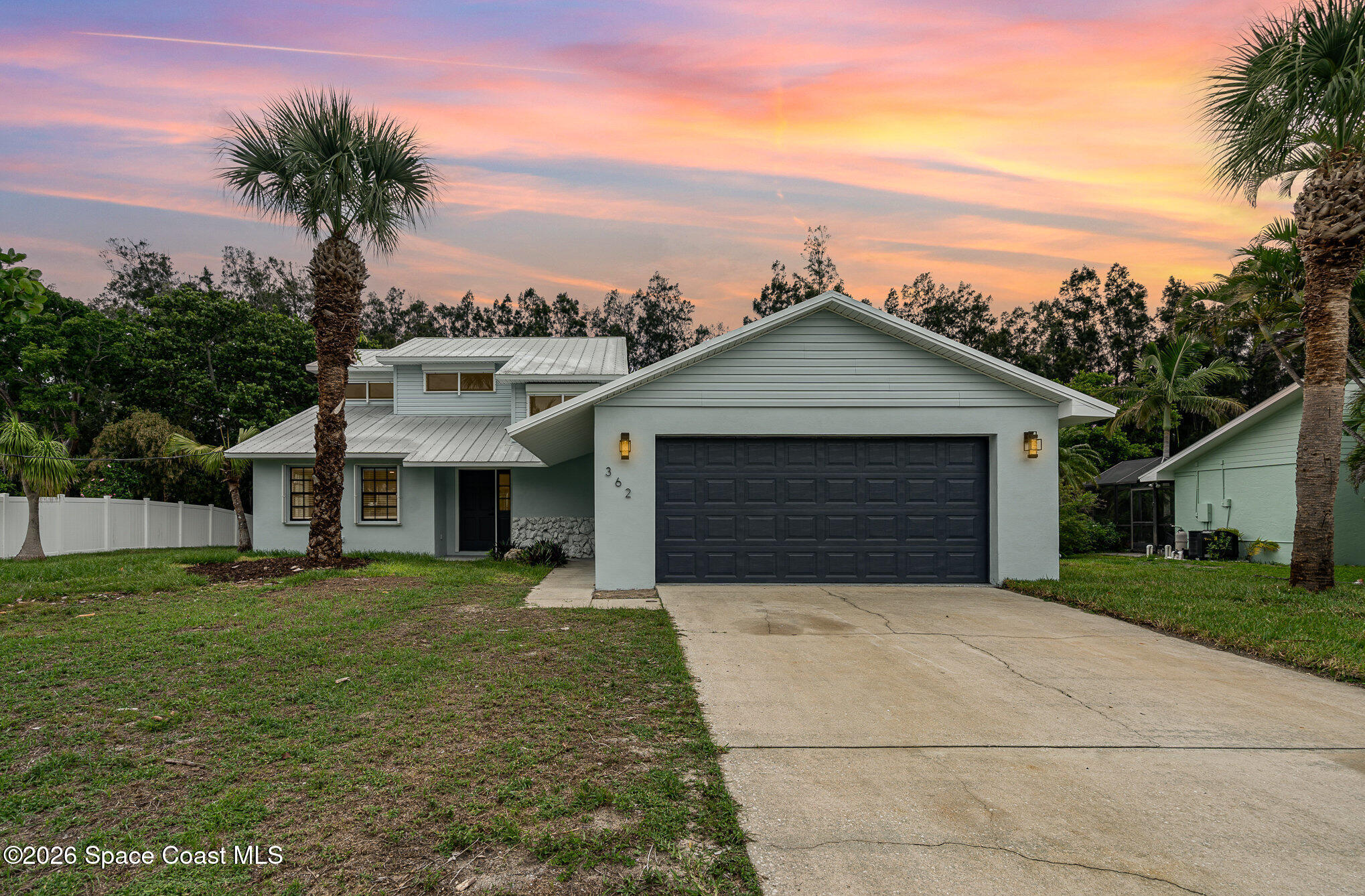 362 Nikomas Way Melbourne Beach, FL 32951 - Photo 2 of 32 a front view of a house with a yard and garage