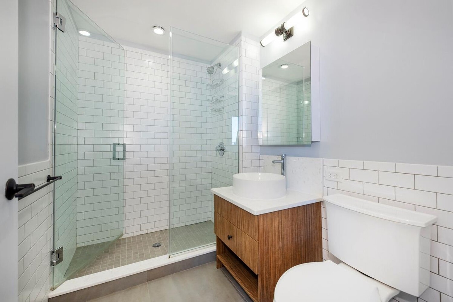 774 Grand Street, Unit 7D Brooklyn, NY 11211 - Photo 5 of 13 a bathroom with a sink toilet vanity and shower