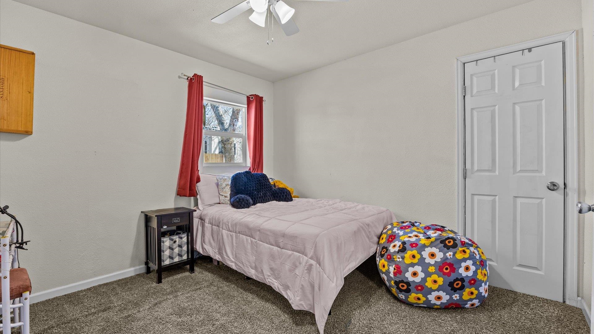 2896 Seely Road Grand Junction, CO 81503 - Photo 17 of 27 a bedroom with a bed and a chandelier