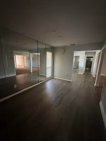 a view of empty room with wooden floor