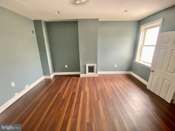 a view of room with window and wooden floor