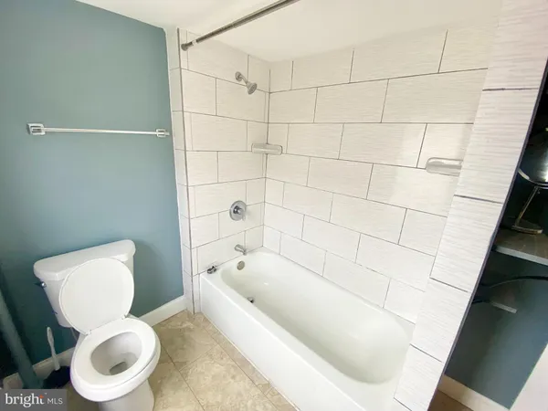 a white toilet sitting next to a bath tub