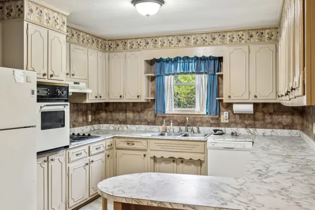 a kitchen with a sink cabinets appliances and a window