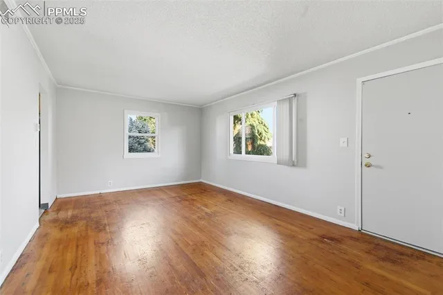 a kitchen with stainless steel appliances granite countertop a sink a stove a refrigerator with grey cabinets and wooden floor