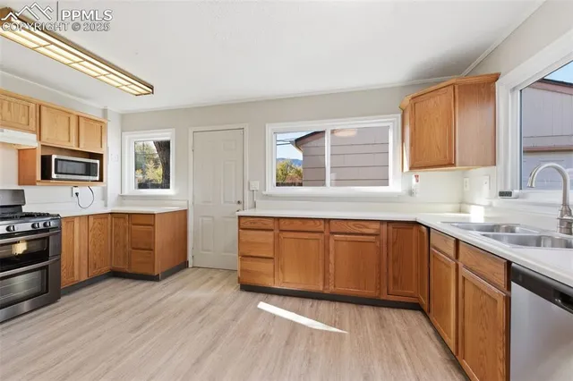 a kitchen with stainless steel appliances granite countertop a refrigerator sink and stove