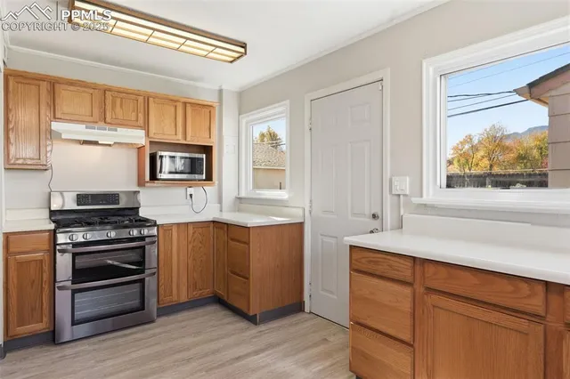 a kitchen with wooden floors and appliances