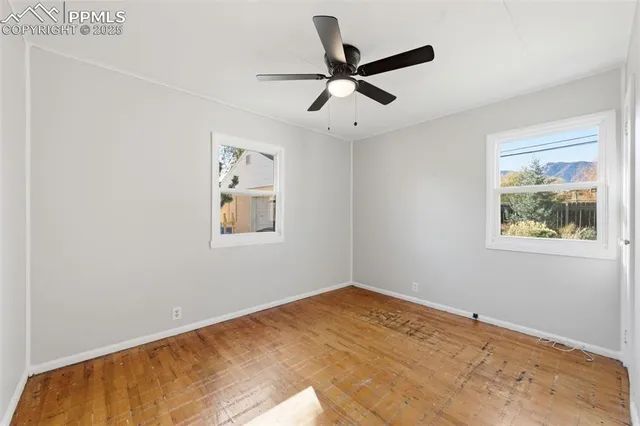 a view of a big room with windows and ceiling fan