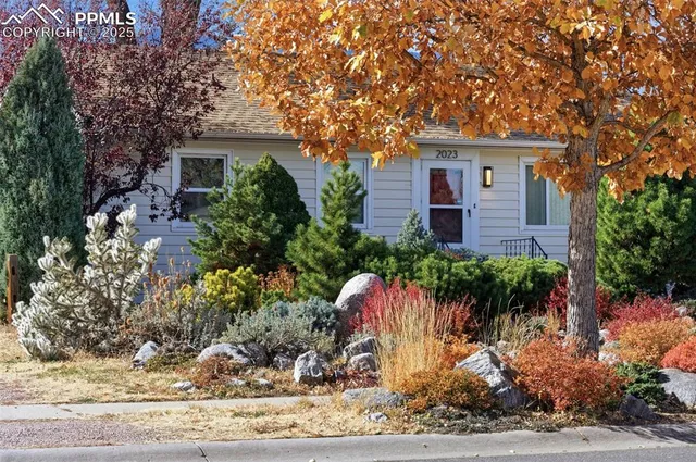 a front view of a house with a yard and potted plants