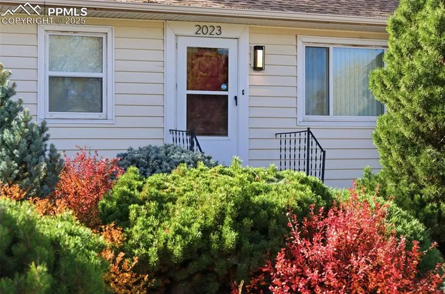 a front view of a house with a lot of flower plants