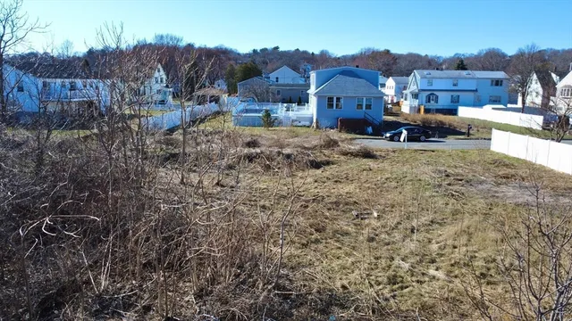 a view of a house with a yard and wooden fence