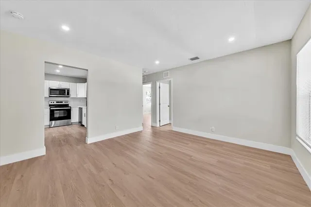 a view of empty room with wooden floor