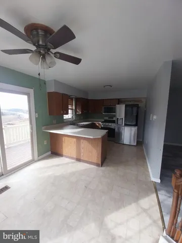 a large kitchen with stainless steel appliances a stove a refrigerator and a sink