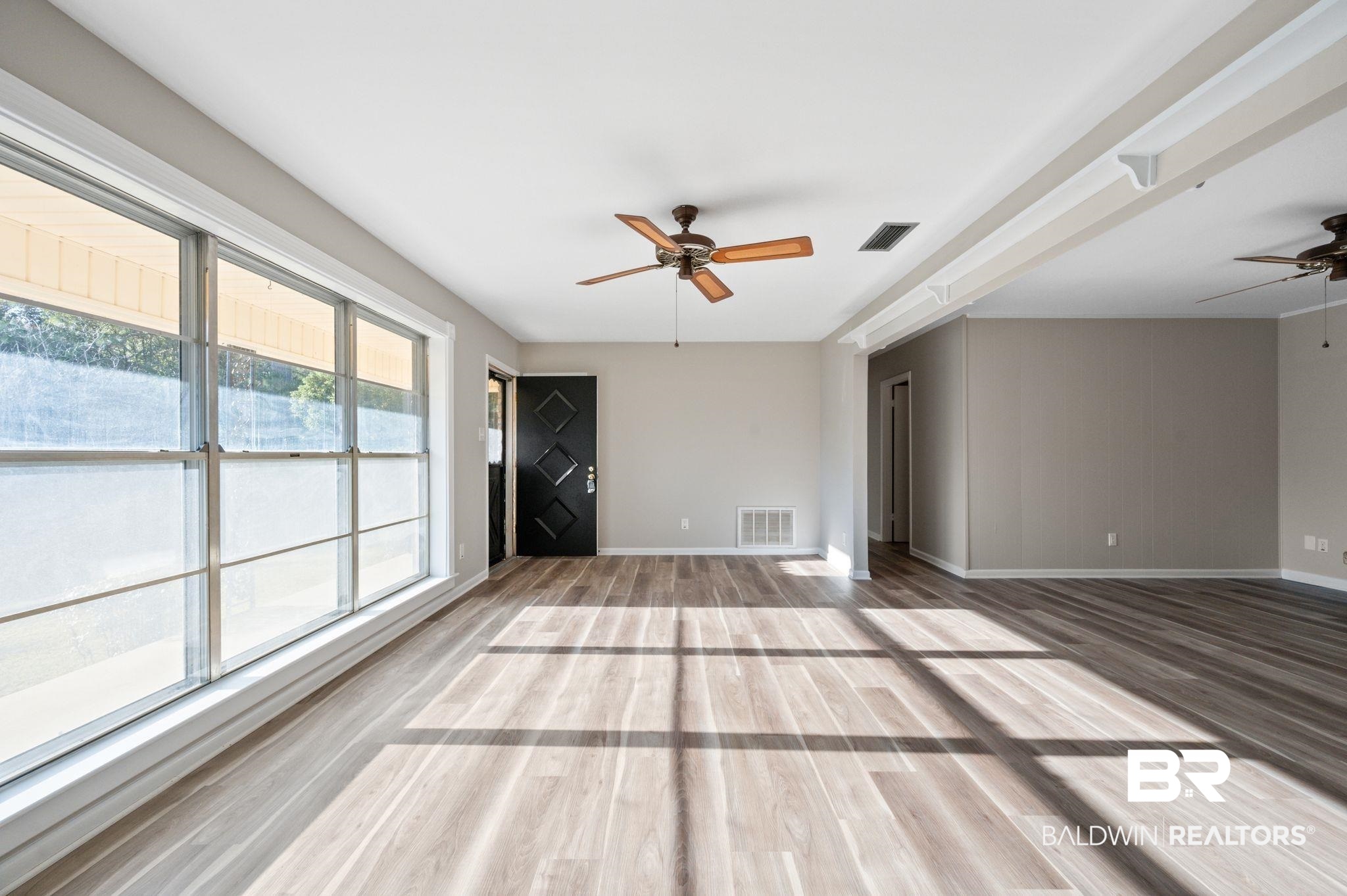 909 Caroline Avenue Daphne, AL 36526 - Photo 9 of 46 Unfurnished living room featuring ceiling fan and hardwood / wood-style flooring