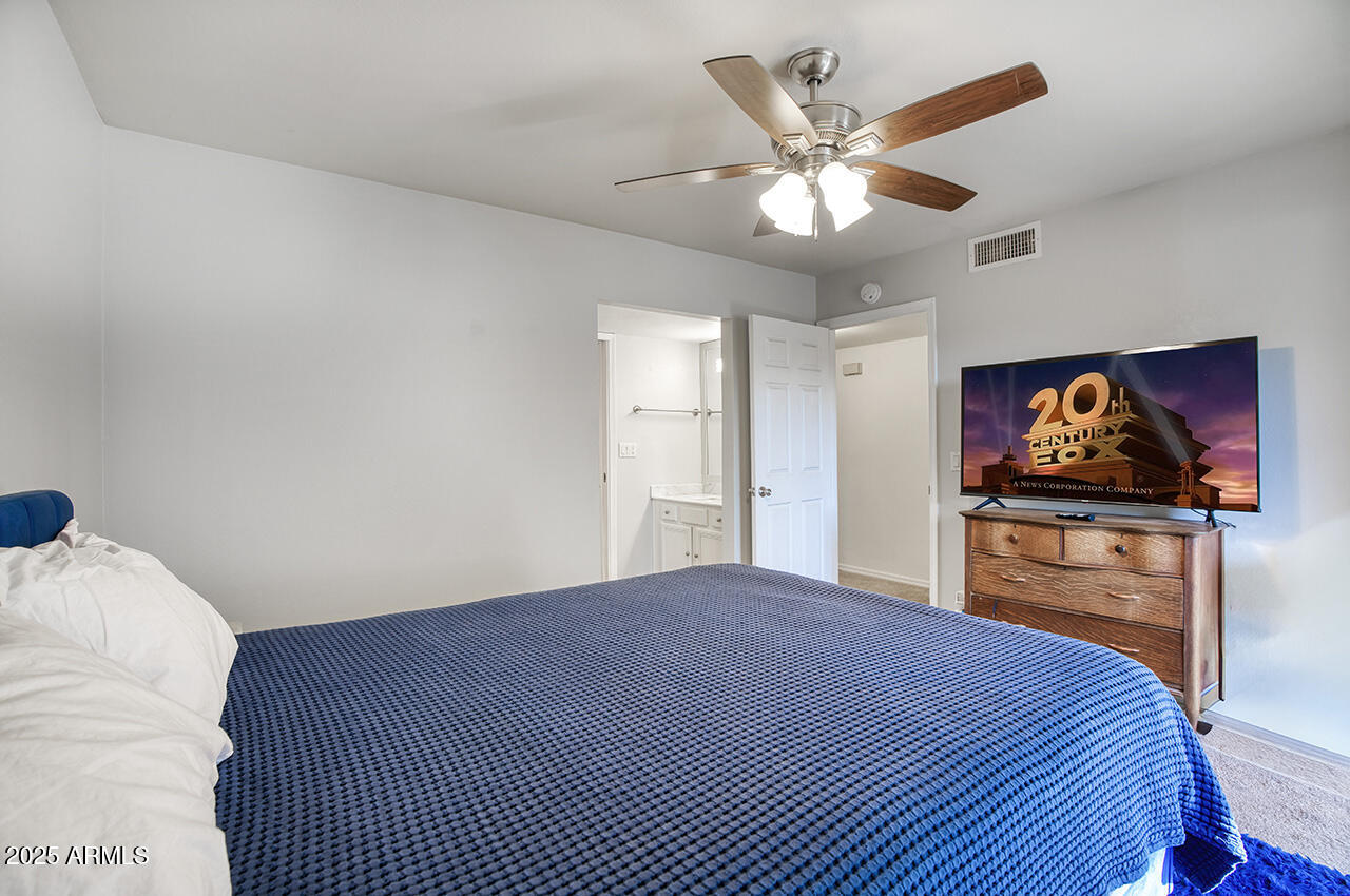 1402 East Guadalupe Road, Unit 149 Tempe, AZ 85283 - Photo 11 of 16 a bedroom with a bed and a chandelier