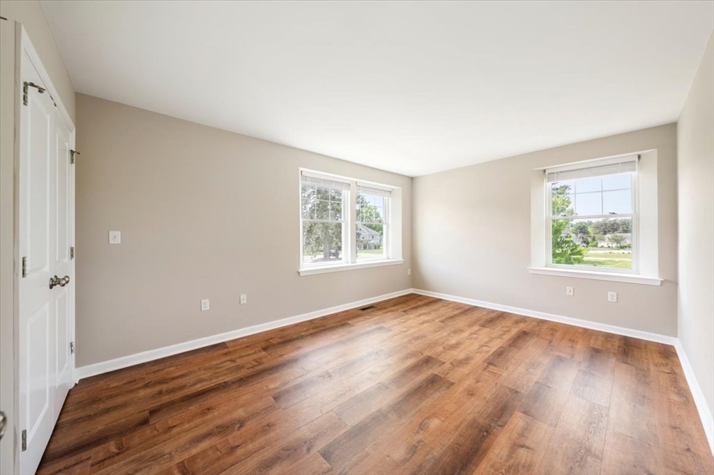 6 Bates Street, Unit A Devens, MA 01434 - Photo 22 of 41 an empty room with wooden floor and windows