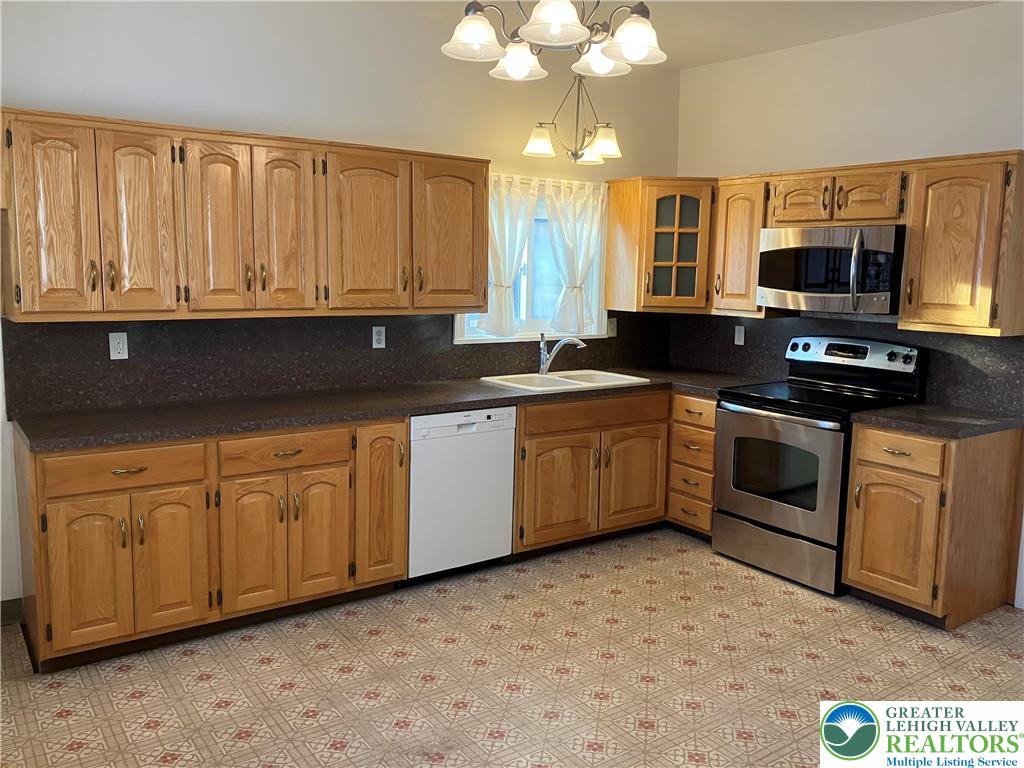 4131 Orefield Road Allentown, PA 18104 - Photo 13 of 20 a kitchen with stainless steel appliances granite countertop a stove a sink and a microwave