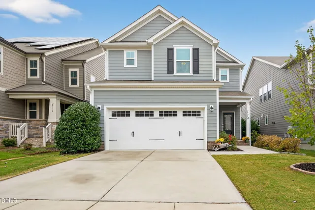 a front view of a house with a yard and garage