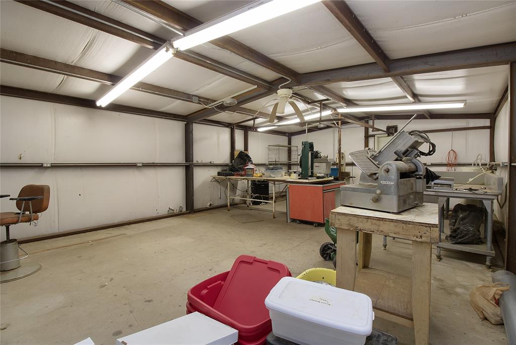 2102 County Road 233 Ballinger, TX 76821 - Photo 12 of 16 a storage room with stainless steel appliances kitchen island granite countertop a sink and cabinets