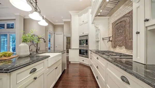 a living room with stainless steel appliances granite countertop furniture and a chandelier