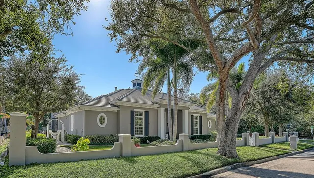 a front view of a house with garden and trees