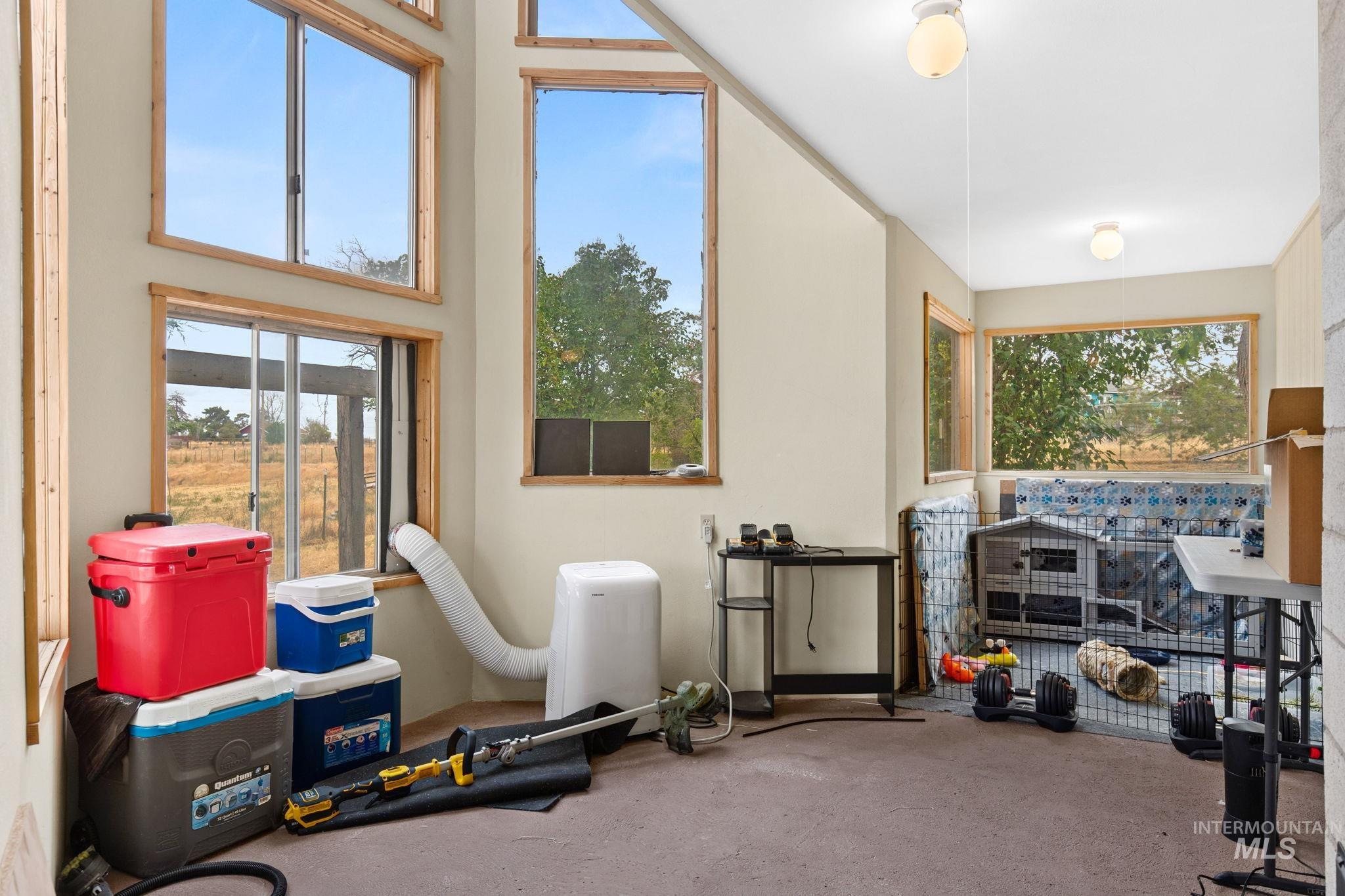 18338 Pride Lane Caldwell, ID 83607 - Photo 18 of 50 Room featuring multiple windows with wood-finish trim, sloped ceilings, and wall-mounted light fixtures