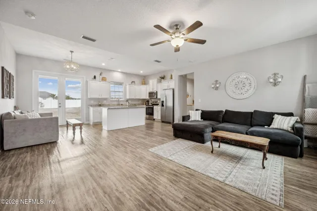 a kitchen with granite countertop white cabinets stainless steel appliances and a sink