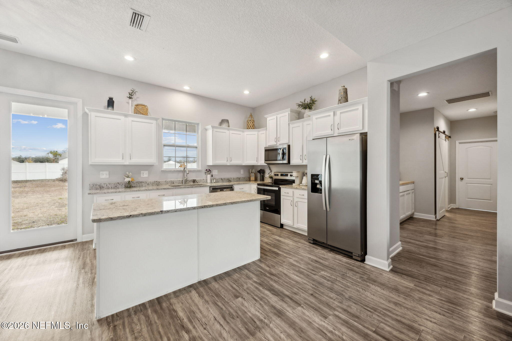 96718 Blackrock Road Yulee, FL 32097 - Photo 20 of 54 a kitchen with stainless steel appliances granite countertop a refrigerator sink and white cabinets
