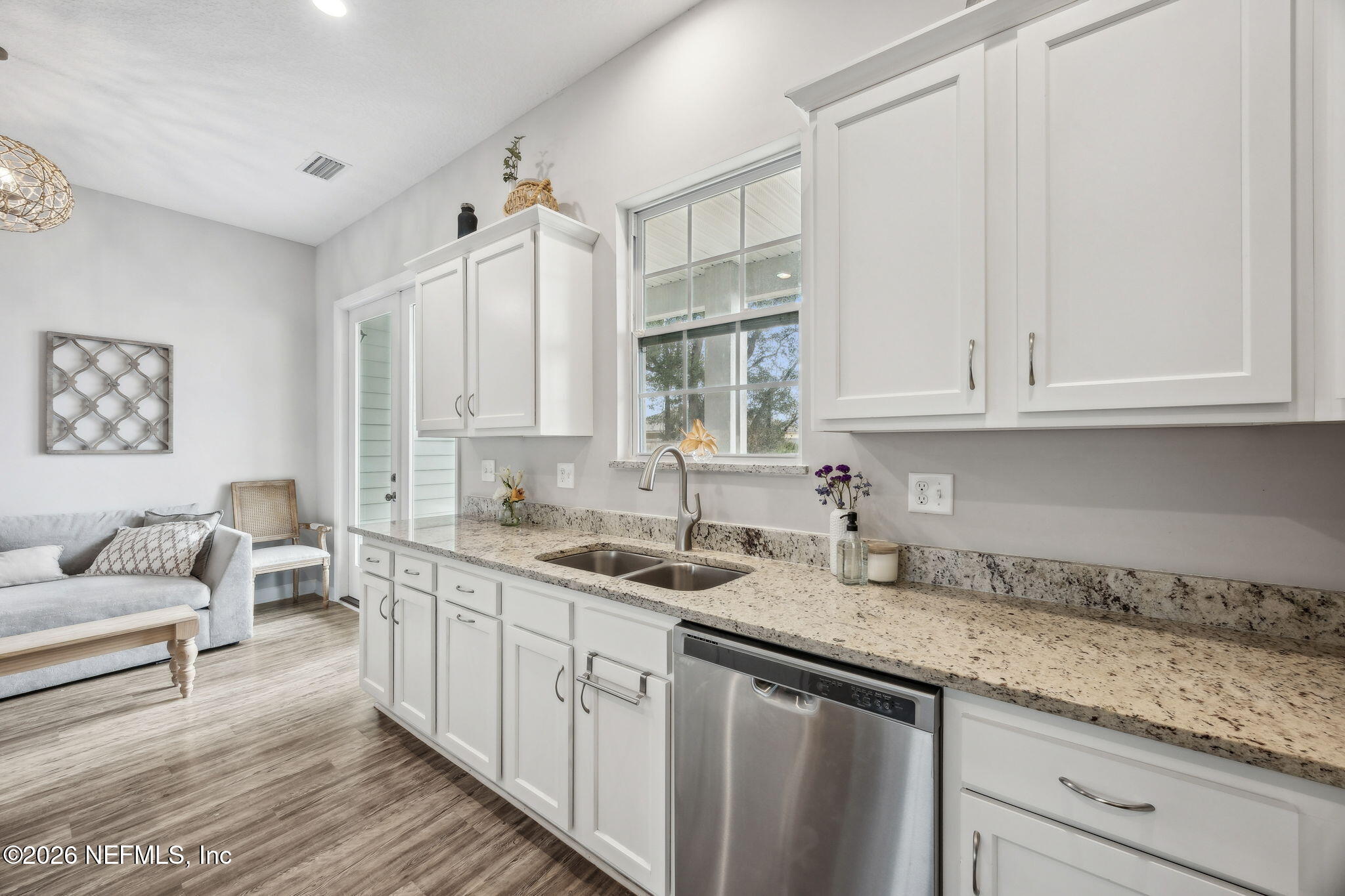 96718 Blackrock Road Yulee, FL 32097 - Photo 24 of 54 a kitchen with a sink dishwasher and white cabinets with wooden floor
