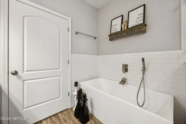 a spacious bedroom with a bed and a flat screen tv