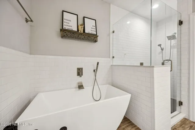 a bathroom with a white bath tub sitting next to shower