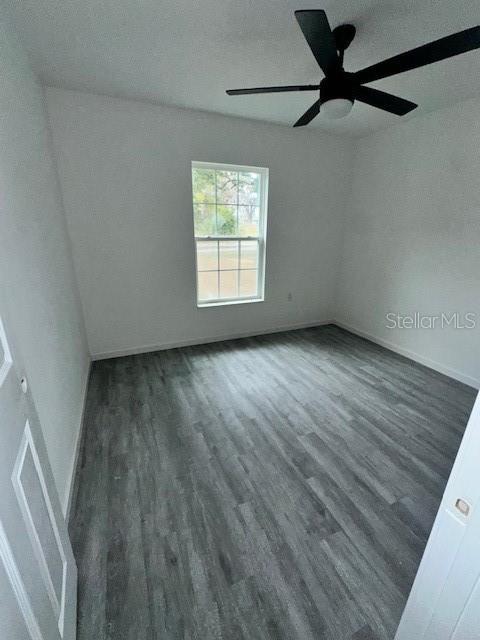 628 Northwest 2nd Street Ocala, FL 34475 - Photo 5 of 7 an empty room with wooden floor fan and windows
