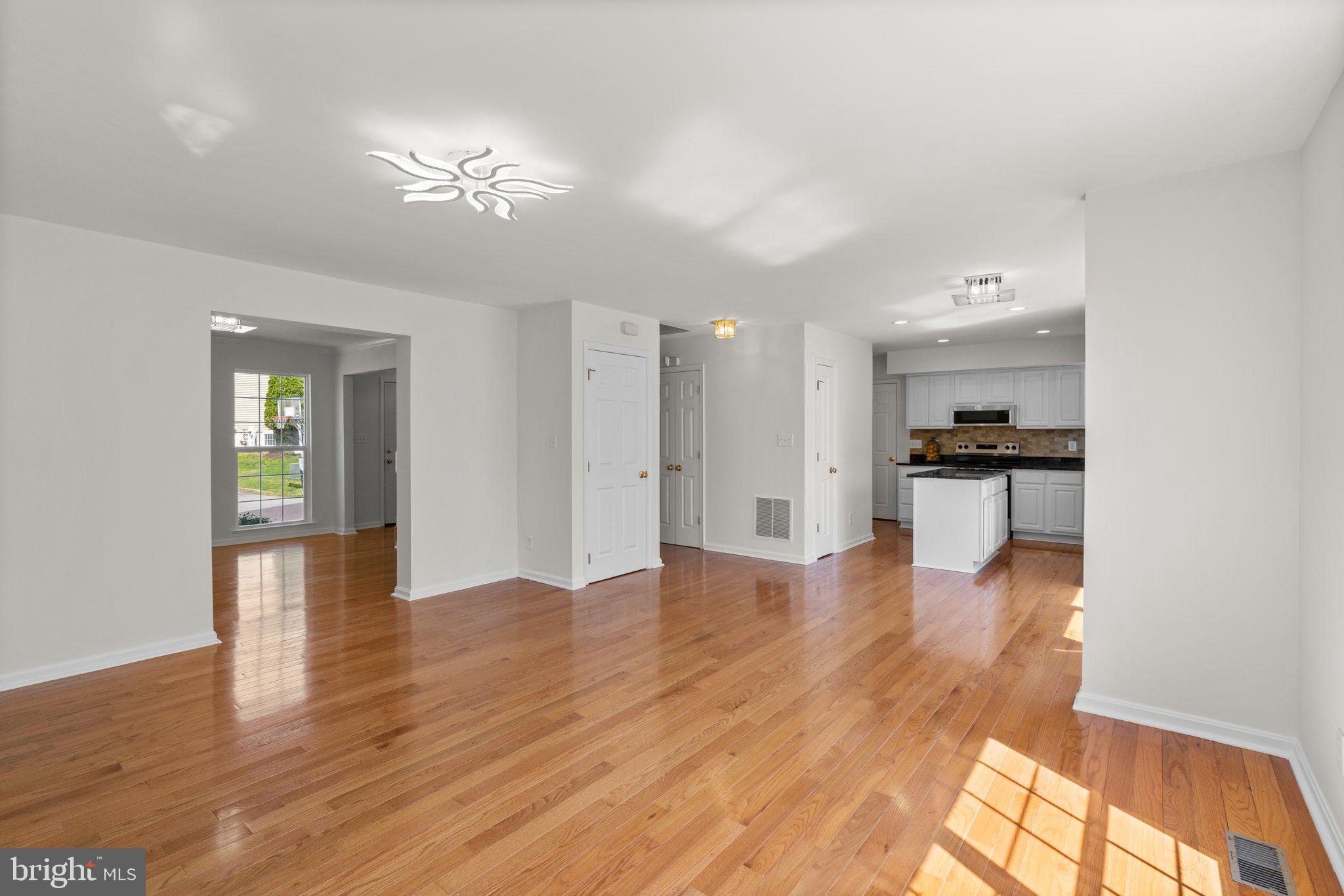 9531 Rommel Drive Columbia, MD 21046 - Photo 14 of 54 a view of empty room with wooden floor and kitchen view