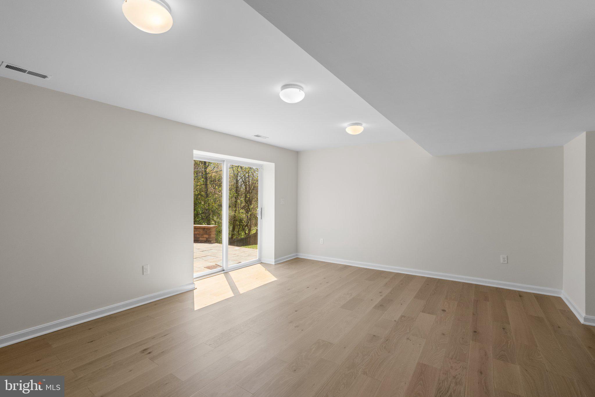 9531 Rommel Drive Columbia, MD 21046 - Photo 38 of 54 an empty room with wooden floor and windows