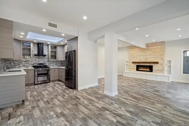 a kitchen with stainless steel appliances granite countertop a refrigerator stove oven and a sink