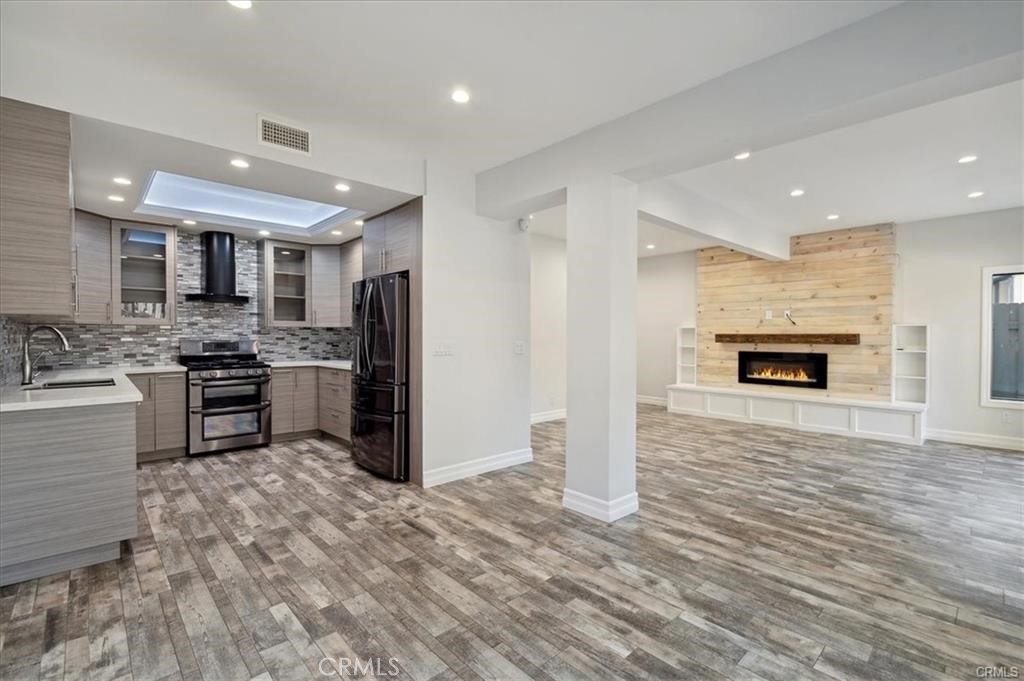 a kitchen with stainless steel appliances granite countertop a refrigerator stove oven and a sink