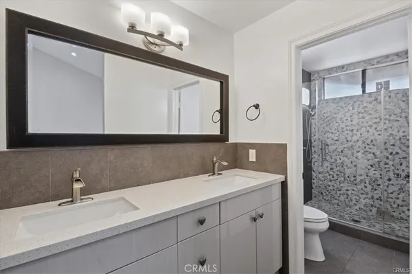 a bathroom with a sink a toilet and a mirror