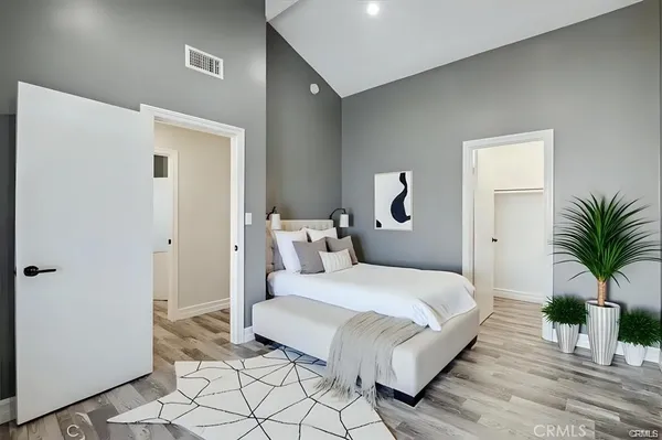 a bedroom with a large bed and a potted plant
