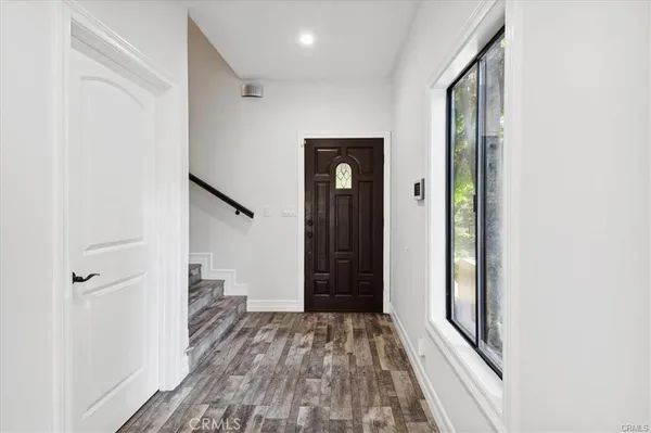 a view of a hallway with wooden floor and staircase