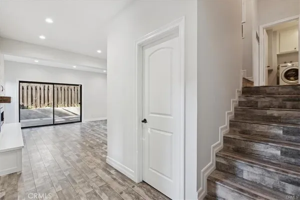 a view of a hallway with wooden floor and entryway