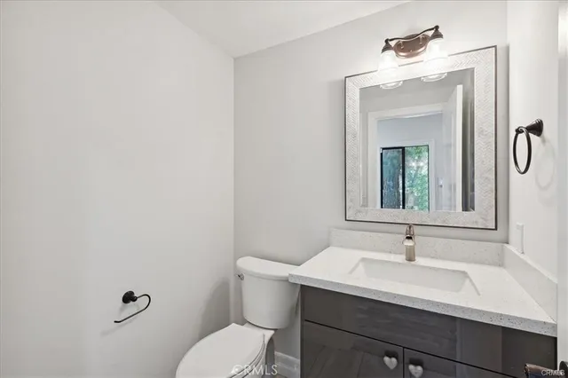 a bathroom with a sink vanity mirror and toilet